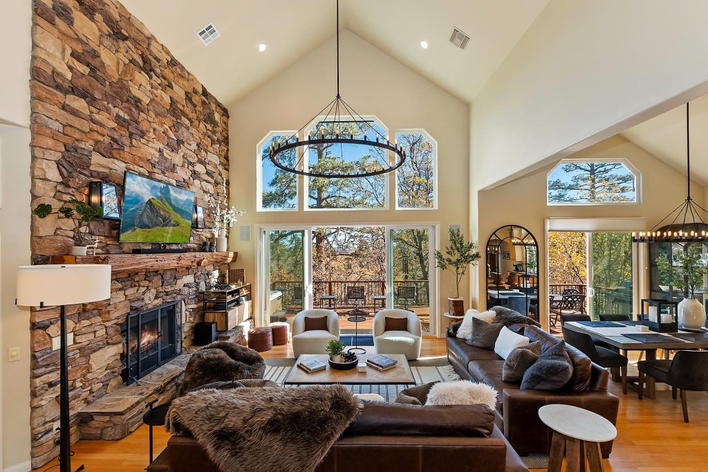 The living room of Sundance Lodge cabin in Big Bear, showcasing a large stone fireplace and inviting seating area.