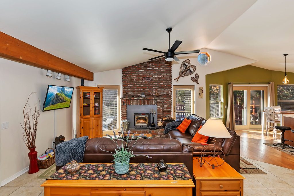 Spacious Eagle Point Retreat living room with brick fireplace, leather seating, wood accents, and modern cabin decor