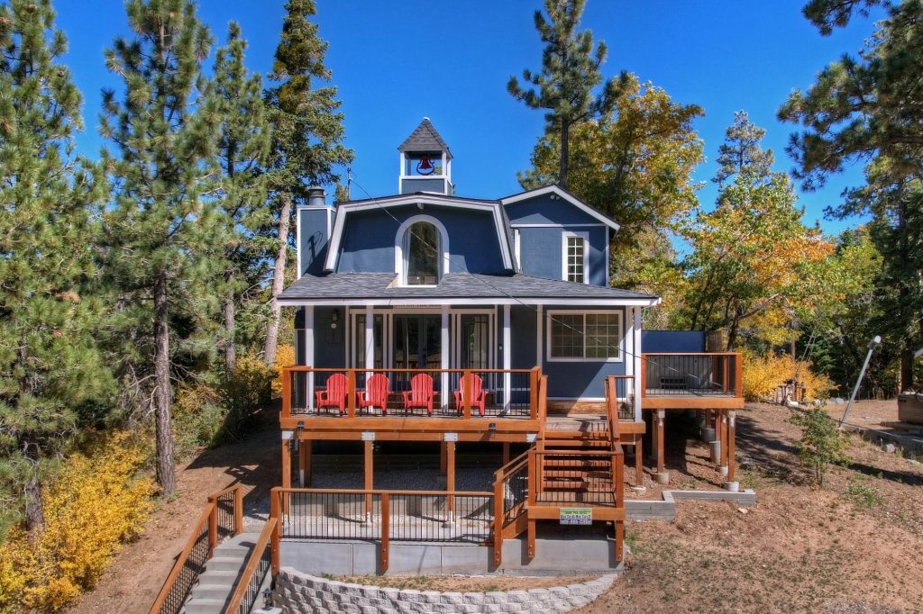 Inn On The Slopes cabin-style property with a covered porch, spacious decks, and surrounding pine trees