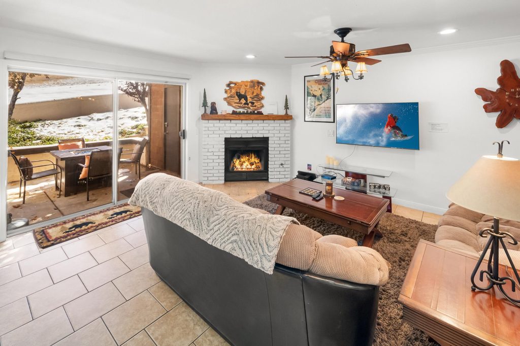Ski Bear Get Away living room with fireplace, snowboarding decor, and snowy outdoor patio