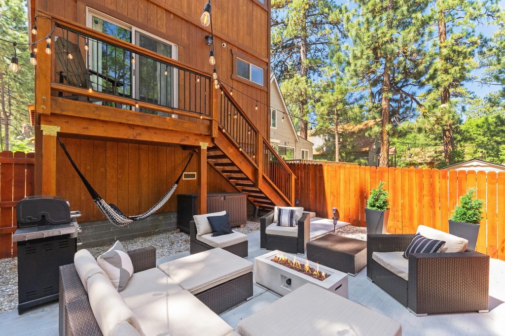 Willowbear Lodge outdoor patio with seating, fire pit, hammock, grill, and string lights