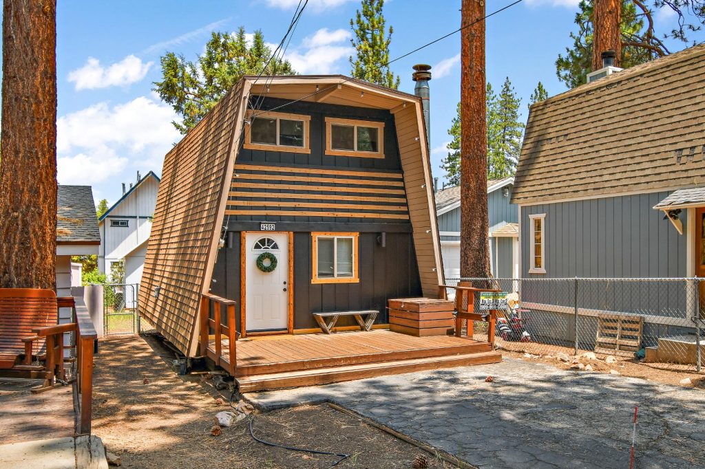 Stephanie's Cabin exterior with wood siding, front deck, and tall pine trees