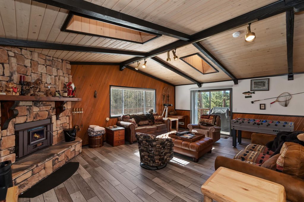 Overlook Chalet living room with stone fireplace, leather seating, and game table