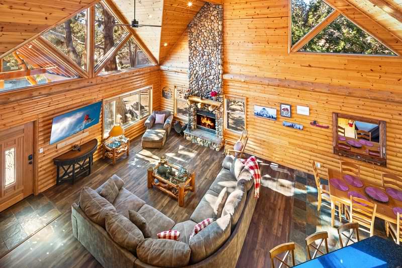 Large wooden living room with fireplace and forest views in Big Bear.