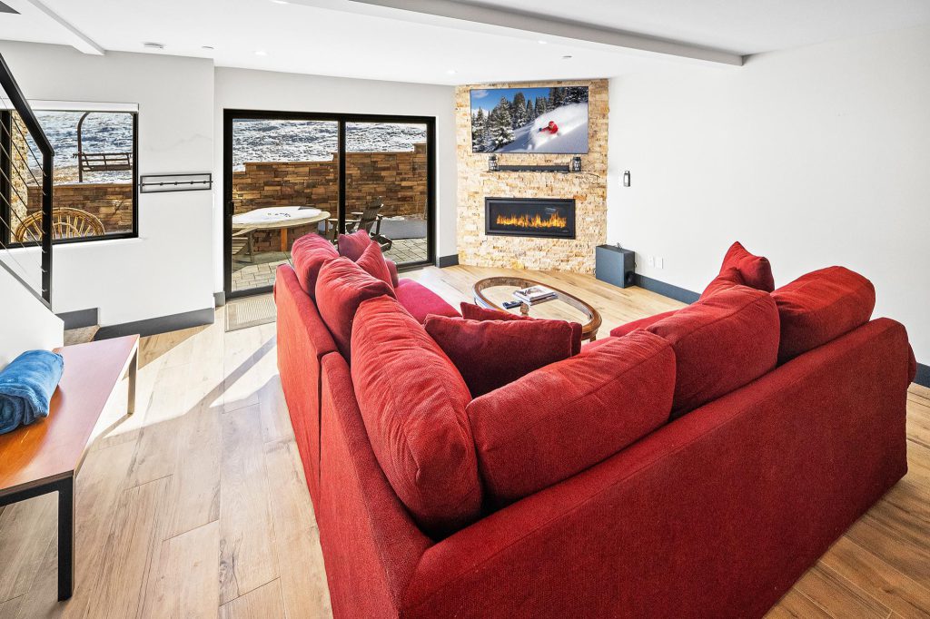 A living room featuring a red couch and a television, set in the Bear Mountain Dropzone environment.