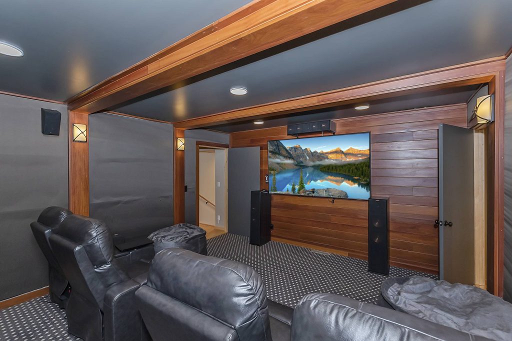 Golden Oak Estate private theater with leather recliners and wood-paneled walls
