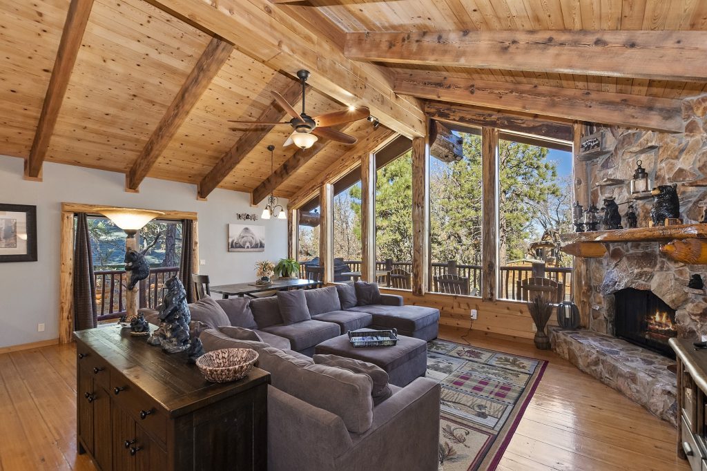 The large living room of the Angels Camp cabin in Big Bear, showcasing a prominent stone fireplace and inviting atmosphere.