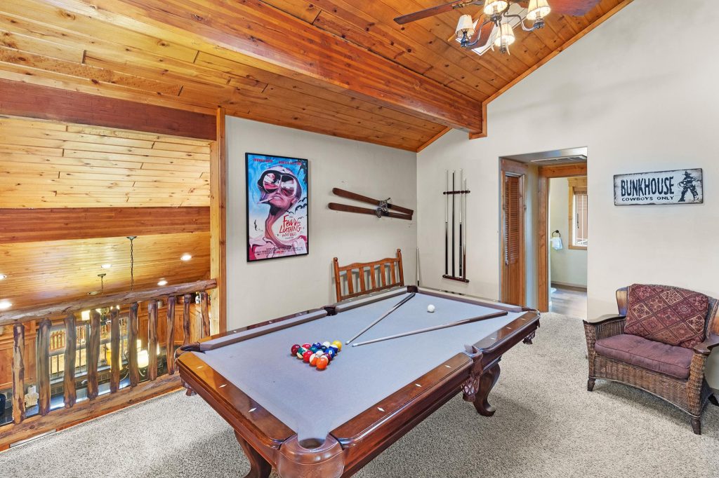 Retreat at Bear Mountain game room with pool table, skis, and rustic mountain decor