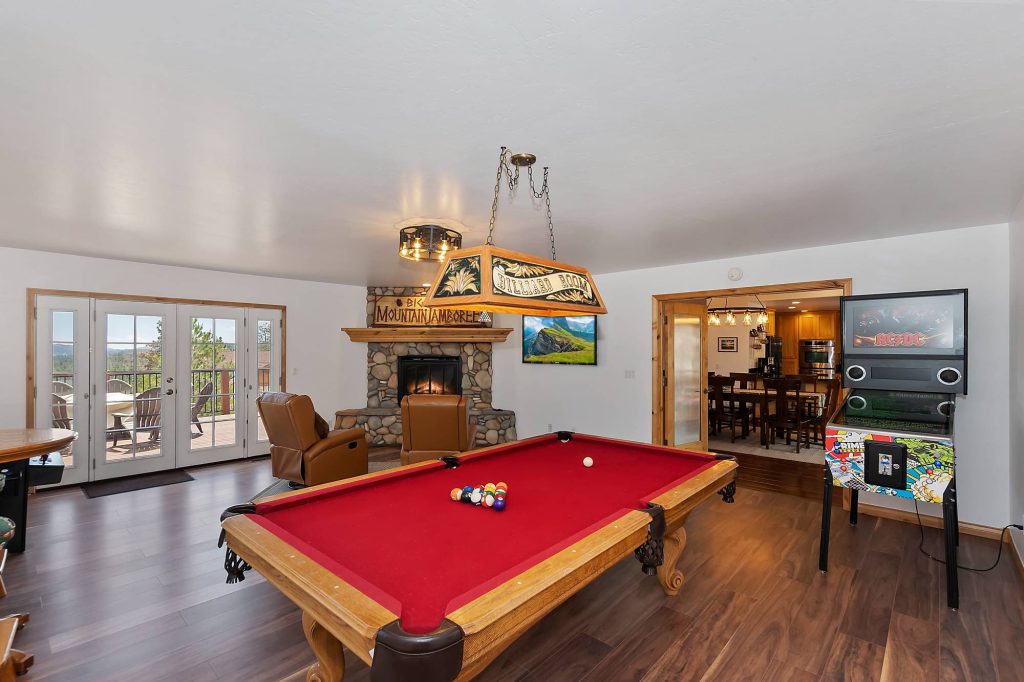 Valley View Lodge game room with a pool table, stone fireplace, arcade game, and mountain views