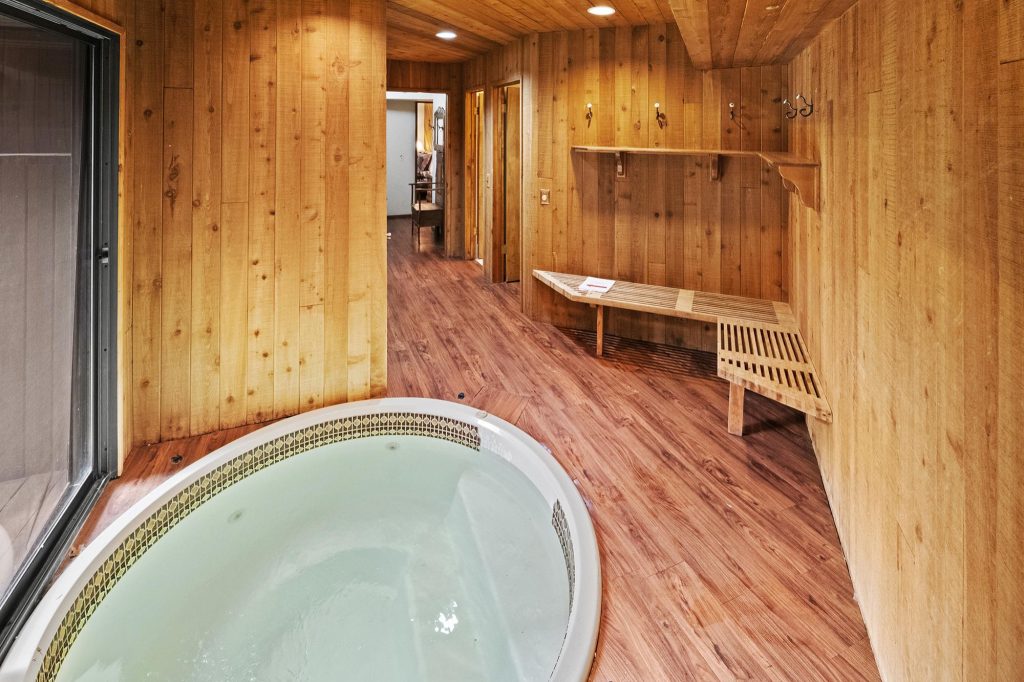Indoor hot tub area at Hawks View cabin with wood panel walls, bench seating, and cozy mountain cabin interior in Big Bear Lake, CA