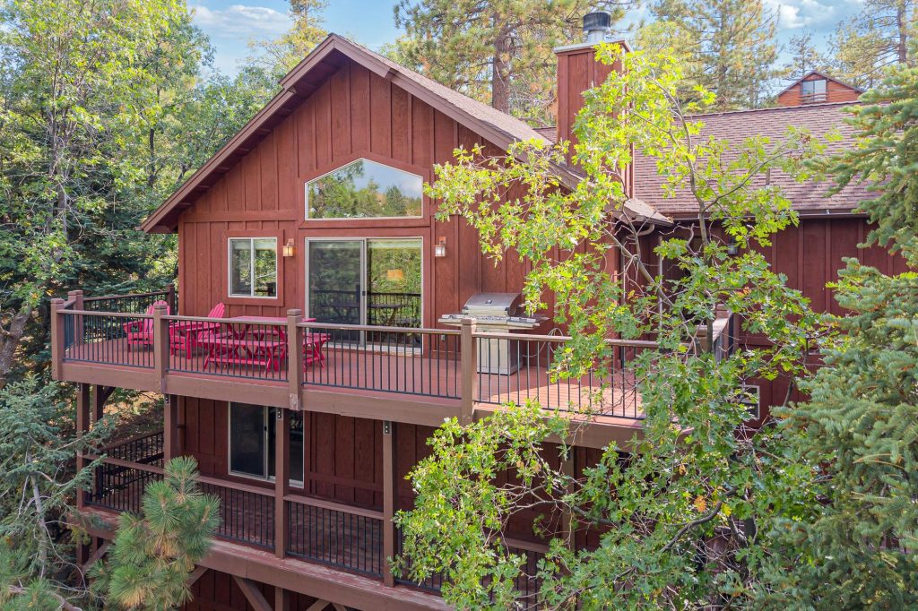 Exterior view of Snowline on Shasta cabin surrounded by pine trees with spacious decks and mountain forest scenery in Big Bear Lake, CA