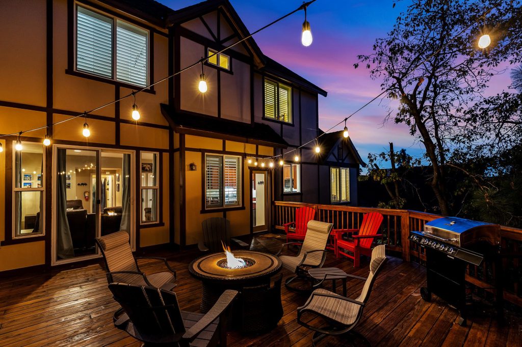 Outdoor deck area at High Timber Family Retreat featuring a fire pit, seating area, string lights, and mountain cabin ambiance