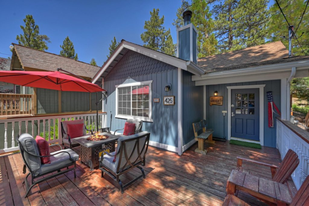 Cuddly Bear Cabin exterior with outdoor seating area, fire table, and forest surroundings