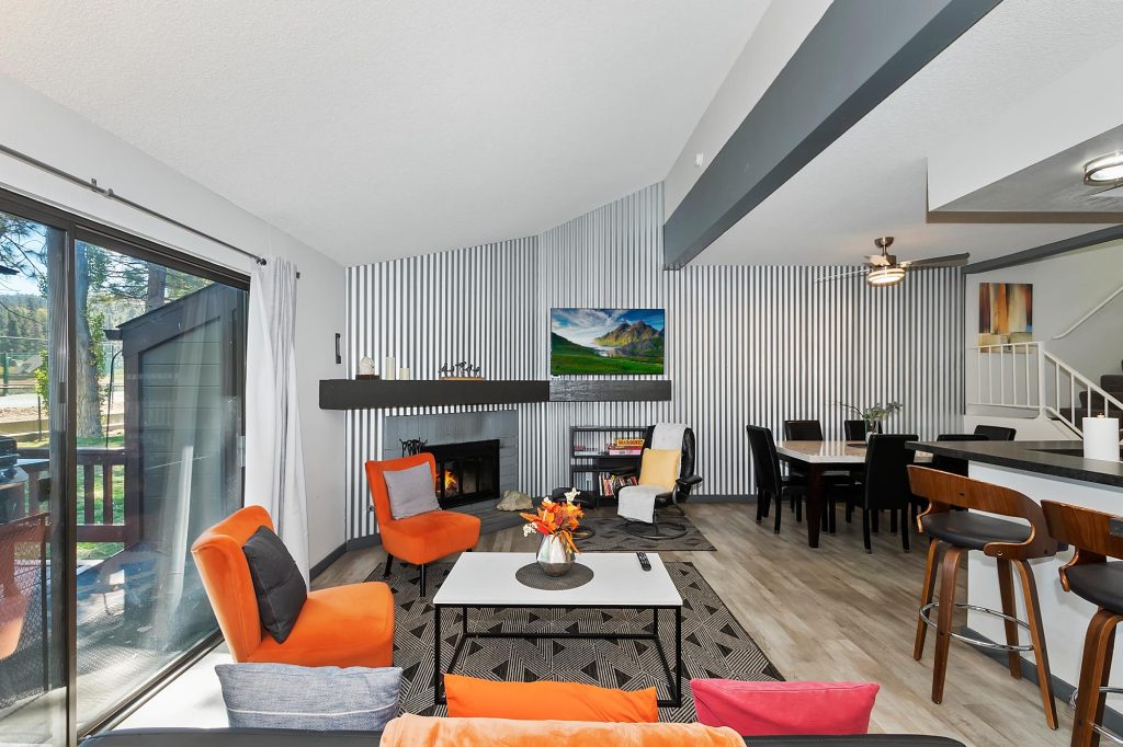 Modern living room interior at Bayshore Condo in Big Bear Lake with fireplace, dining area, and contemporary cabin design