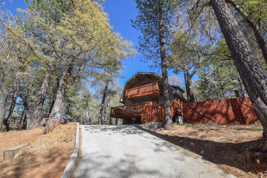Wood cabin retreat surrounded by trees with outdoor deck space in Big Bear Lake
