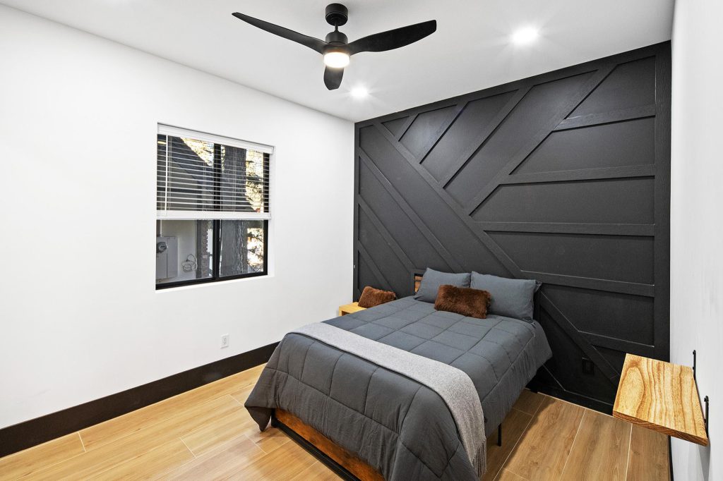 A bedroom featuring a black wall and wooden floor, located in The Gateway Club at Big Bear.