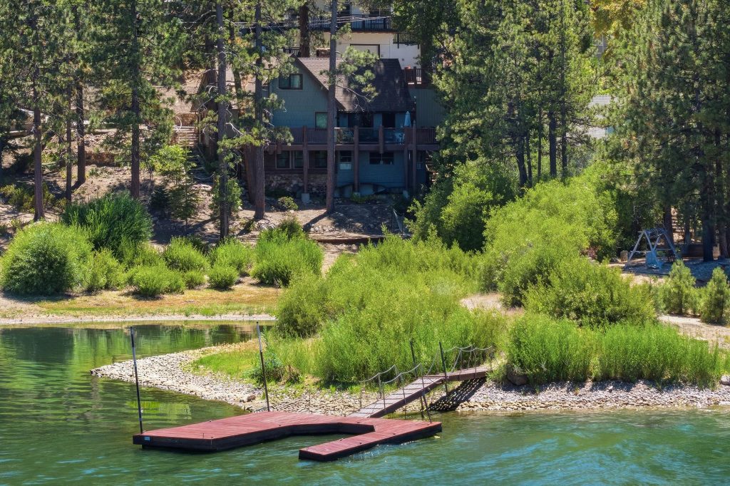 Lakefront cabin view at Boulder Bay Cover with private dock, green shoreline, and peaceful Big Bear Lake scenery
