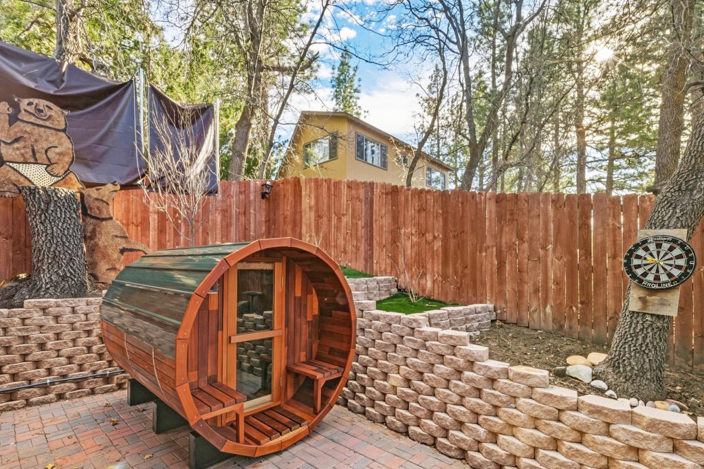 Outdoor barrel sauna at Casa Luna cabin featuring a wooden design, private patio setting, and relaxing backyard retreat in Big Bear City, CA