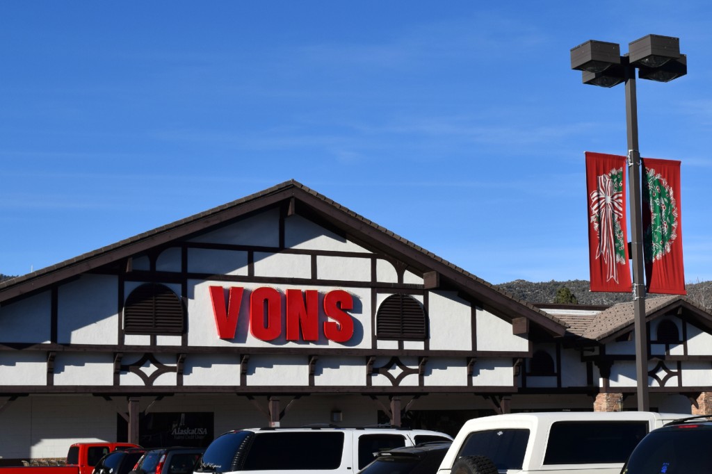 The exterior of a Vons supermarket building, with the red "VONS" logo on a white and brown facade, under a clear blue sky.