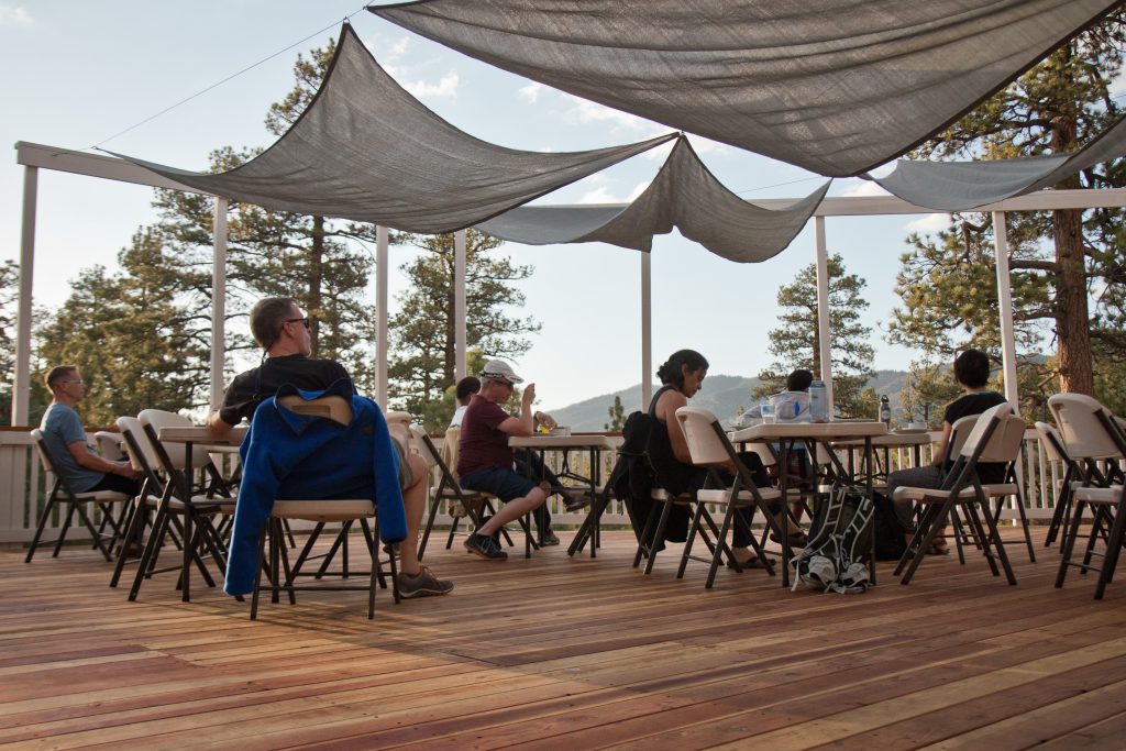 Outdoor deck gathering at Bog Bear Retreat Center with mountain views.
