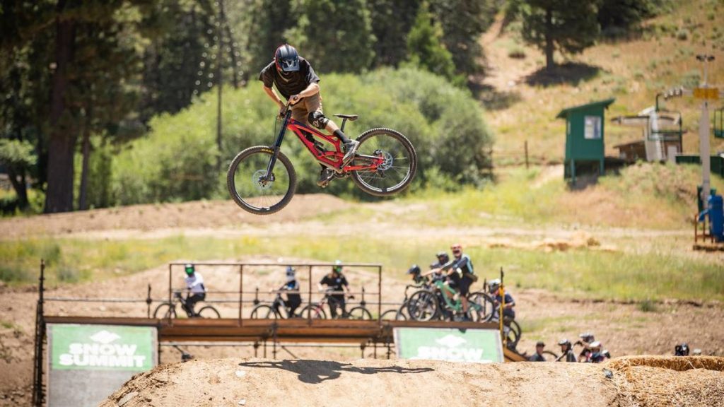 Athlete performing extreme sports in an outdoor mountain setting with spectators in the background