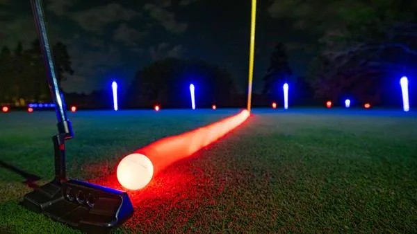 Night golf scene with glowing golf ball and illuminated targets
