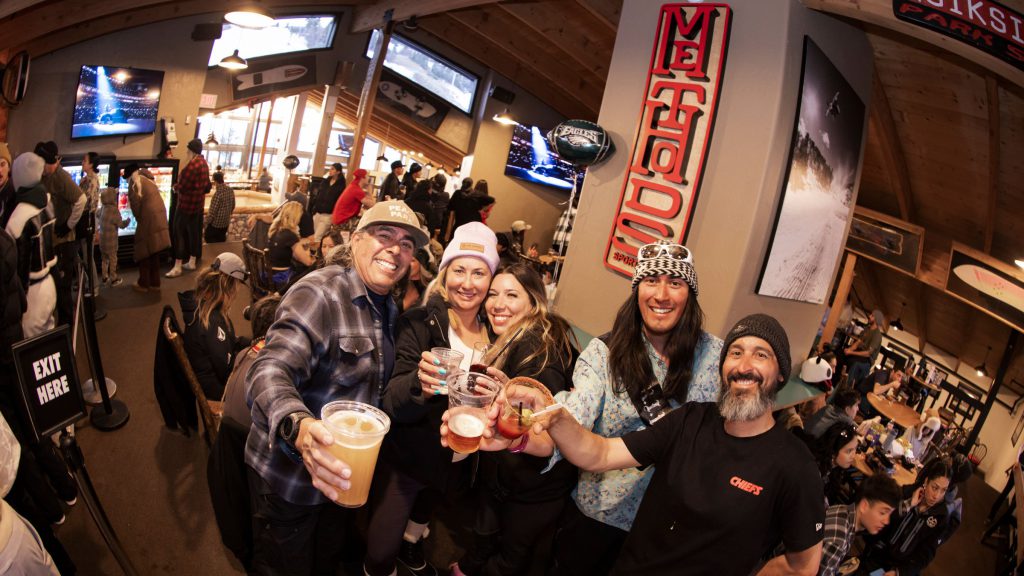 Friends raising drinks during a lively Super Sunday viewing party at Big Bear Mountain Resort