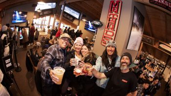 Friends raising drinks during a lively Super Sunday viewing party at Big Bear Mountain Resort