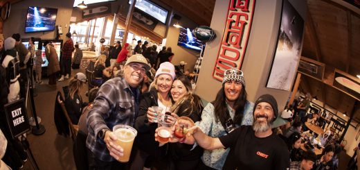 Friends raising drinks during a lively Super Sunday viewing party at Big Bear Mountain Resort