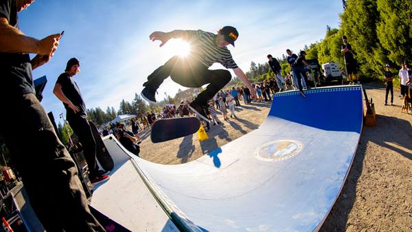Skateboarder performing a trick on a mini ramp during an outdoor event in Big Bear.