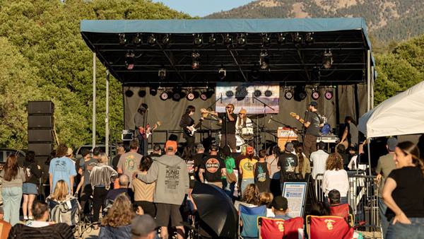 Live band performing on stage at the Moonridge Concert Series with attendees watching.
