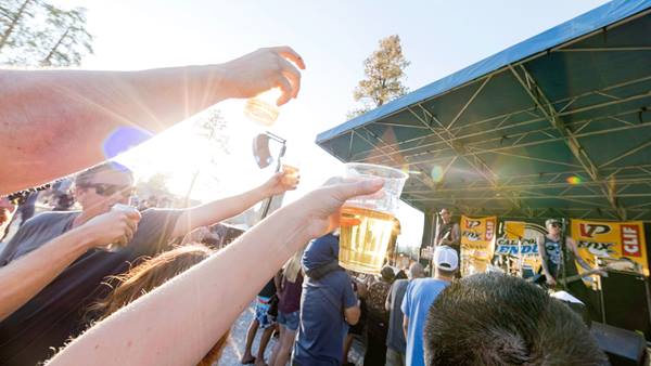 Guests raising beer cups while enjoying live entertainment at Snow Summit Bear Garden.
