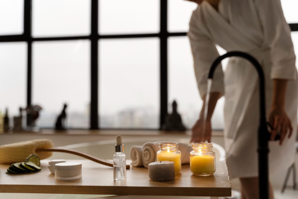 Spa essentials like candles, rolled towels, and a bath being filled for relaxation at Big Bear.