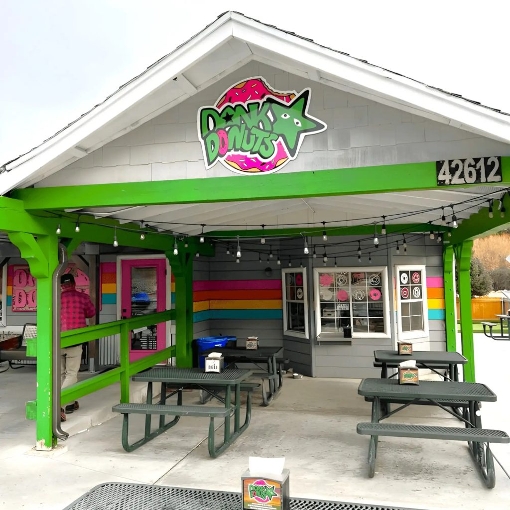Dank Donuts storefront in Big Bear Lake with logo signage and outdoor picnic seating