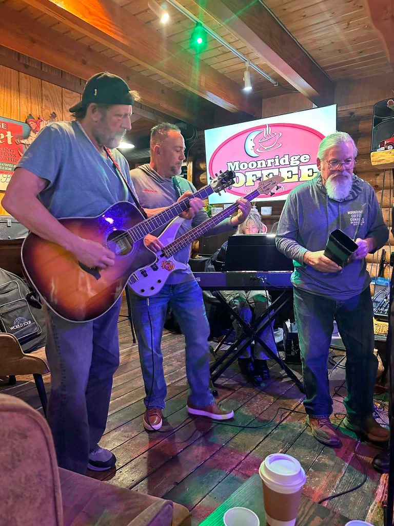Live music performance at Moonridge Coffee Company with musicians playing guitar and bass