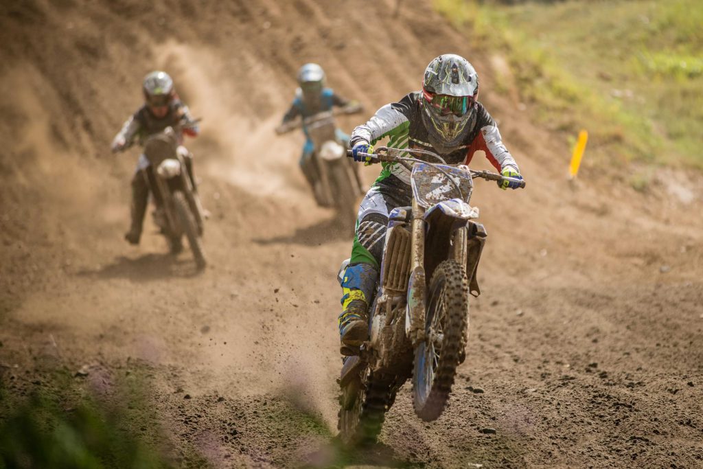 A group of motocross riders competing in a race on a dirt track at Big Bear