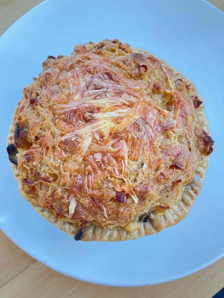 Top view of a baked cheese pot pie showing a golden, melted cheese crust.