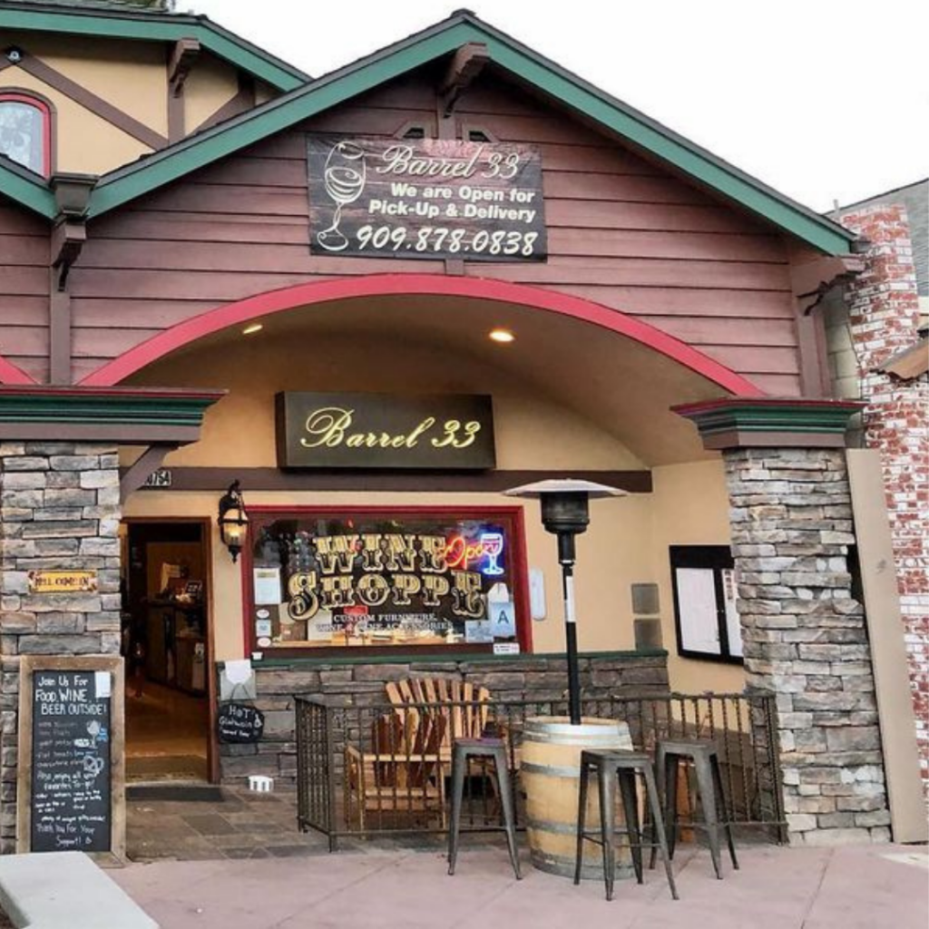 The exterior of Barrel 33, a wine and beer shop in Big Bear, with a sign advertising pickup and delivery.
