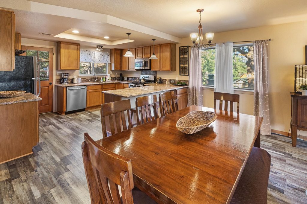 Spacious Bear Escapes cabin kitchen and dining area with wood cabinetry and modern appliances.