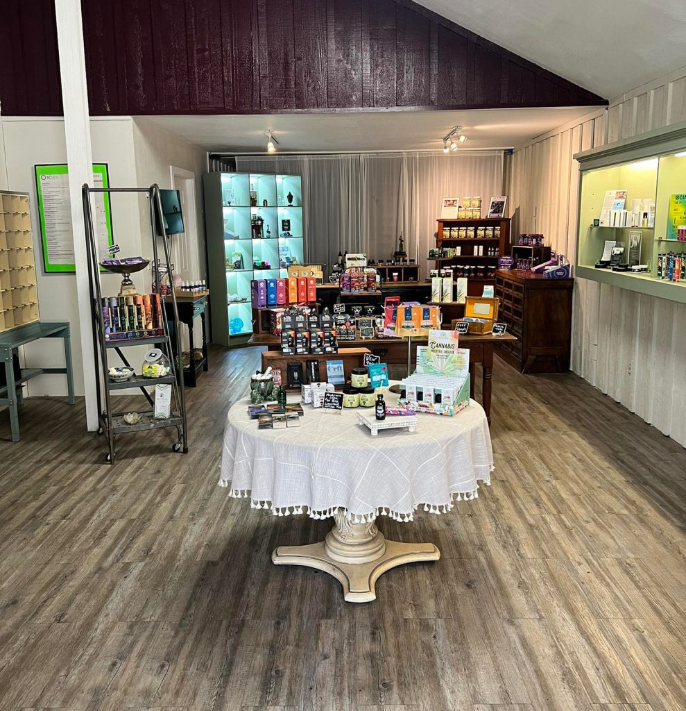 Front section of Bear Valley Wellness Center with a round table displaying various wellness products, shelves in the background with natural products.
