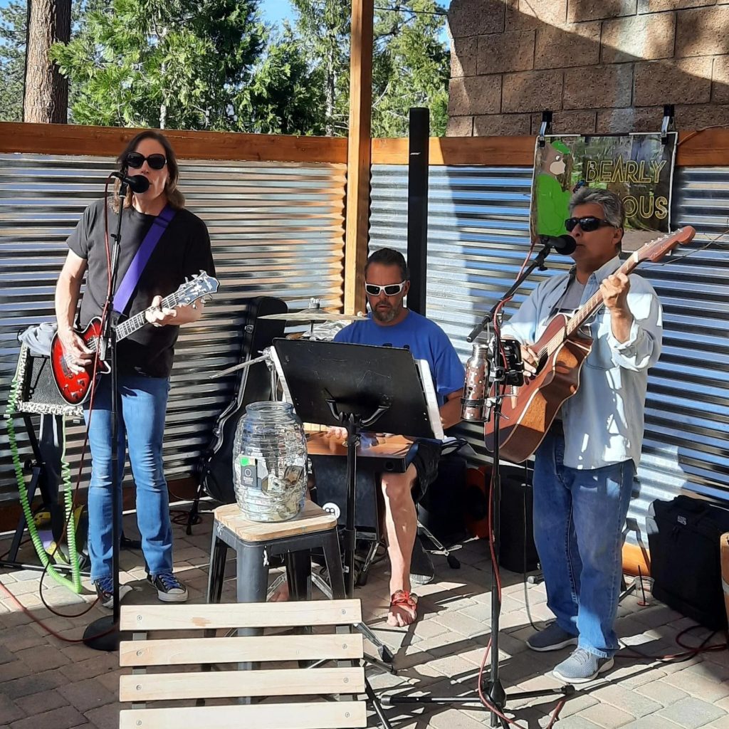 Live music performance by Bearly Famous with musicians playing guitars at an outdoor venue
