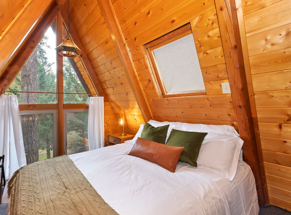 Warm wooden cabin bedroom with forest views in Big Bear.
