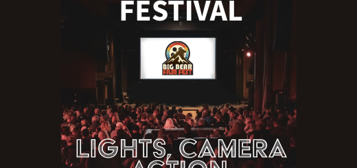 Big Bear Film Festival logo on a white movie theater screen. Theater crowd sitting in seats in dark theater looking at screen.