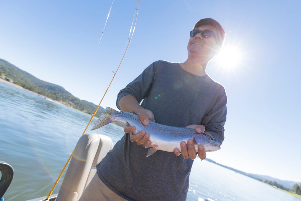 A man holds a fish he caught at Big Bear.