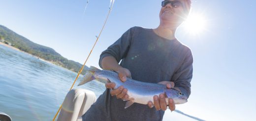 A man holds a fish he caught at Big Bear.