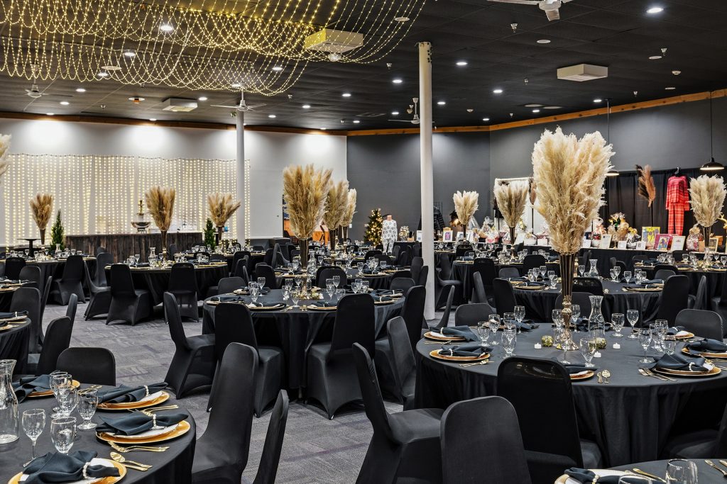 Close-up of banquet table setup with gold centerpiece and tablewar