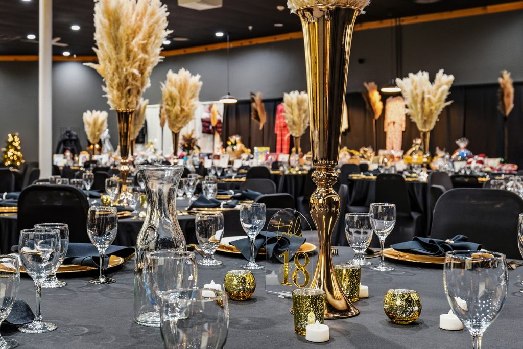 Wide view of decorated banquet hall with hanging lights and tables