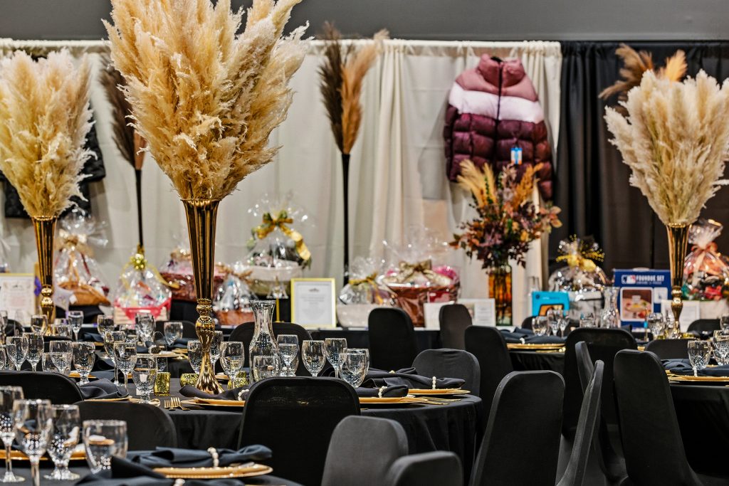 Banquet hall with pampas grass centerpieces and decorated tables for formal event