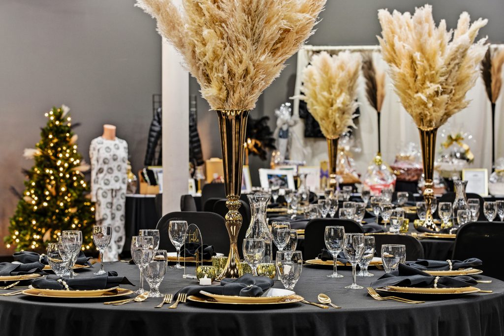 Luxury event table arrangement with tall gold vases and pampas grass decor