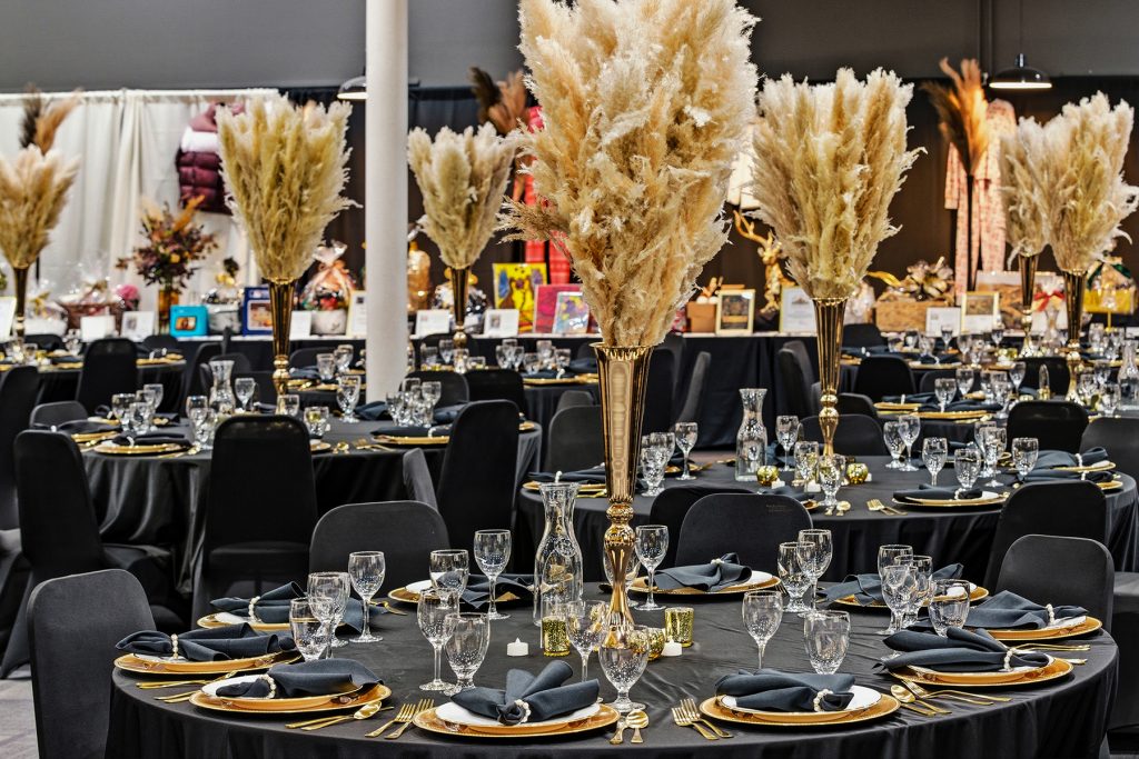 Stylish banquet seating layout with gold and black themed table decor